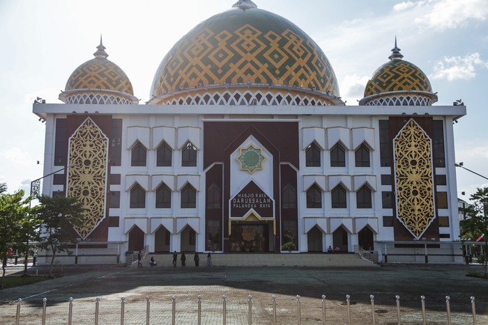 Warga berjalan di area Masjid Raya Darussalam yang berdesain ornamen khas Dayak Kalimantan Tengah, di Palangka Raya, Kalimantan Tengah, Selasa (12/4/2022). Masjid yang dibangun tahun 1984 lalu direnovasi dan diresmikan oleh Pemprov Kalteng pada tahun 2015 itu merupakan destinasi wisata religi di Palangka Raya dengan desain motif simbol talawang khas suku Dayak Kalteng. ANTARA FOTO/Makna Zaezar/tom.