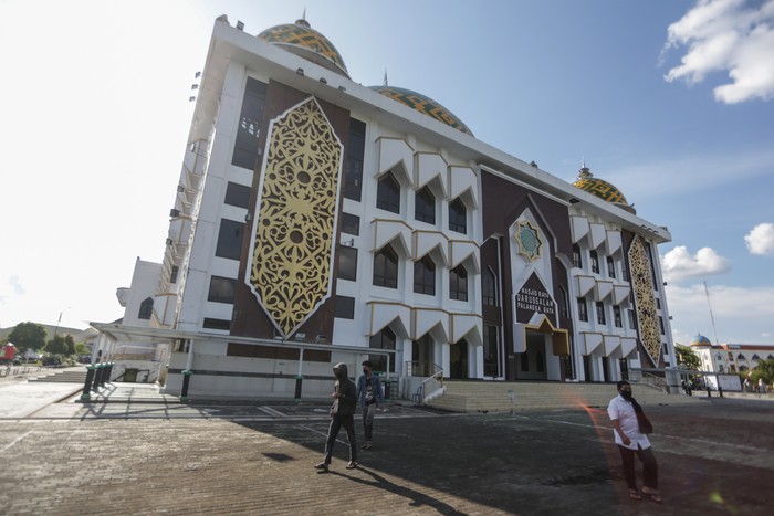 Warga berjalan di area Masjid Raya Darussalam yang berdesain ornamen khas Dayak Kalimantan Tengah, di Palangka Raya, Kalimantan Tengah, Selasa (12/4/2022). Masjid yang dibangun tahun 1984 lalu direnovasi dan diresmikan oleh Pemprov Kalteng pada tahun 2015 itu merupakan destinasi wisata religi di Palangka Raya dengan desain motif simbol talawang khas suku Dayak Kalteng. ANTARA FOTO/Makna Zaezar/tom.