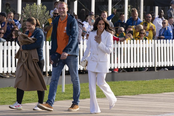 Meghan Markle, Duchess of Sussex, waves upon arrival at the Invictus Games venue in The Hague, Netherlands, Friday, April 15, 2022. The week-long games for active servicemen and veterans who are ill, injured or wounded opens Saturday, April 16, 2022, in this Dutch city that calls itself the global center of peace and justice. (AP Photo/Peter Dejong)