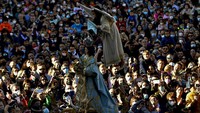 Momen Veronica Serrano (7) diangkut di udara dengan mengenakan tali kekang saat ia ikut serta dalam perayaan Minggu Paskah yang digelar di Tudela, Spanyol utara. AP Photo/Alvaro Barrientos.