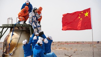 Petugas penyelamat membantu astronot China Wang Yaping keluar dari kapsul usai kembali dari luar angkasa dan mendarat di bumi pada Sabtu (16/4) waktu setempat. China Daily via REUTERS.
