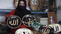 Perajin menunjukkan lukisan kaligrafi Arab pada piring keramik di rumah produksi Fairus Art, Desa Plumbon, Sukoharjo, Jawa Tengah, Sabtu (16/4/2021).