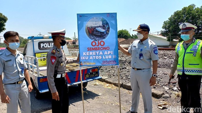 Polisi dan Jasa Raharja memasang spanduk imbauan dengan kata-kata lucu berbahasa Jawa di Perlintasan KA tak berpalang pintu.