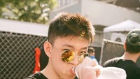 Potret keren Rich Brian juga terlihat ketika menikmati sebotol air mineral dingin yang menyegarkan. Foto: Instagram @brianimanuel