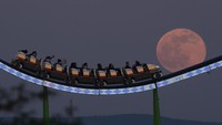 Sebuah wahana roller coaster di Frankfurt terlihat menyundulbulan purnama.