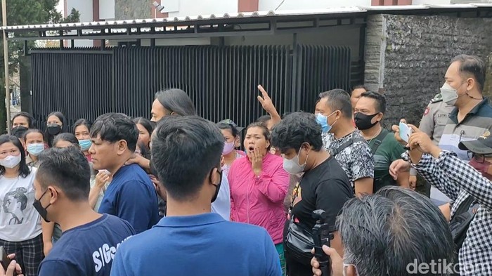 Winner (berkaus biru dongker) dihujat warga saat dibawa polisi ke dalam mobil