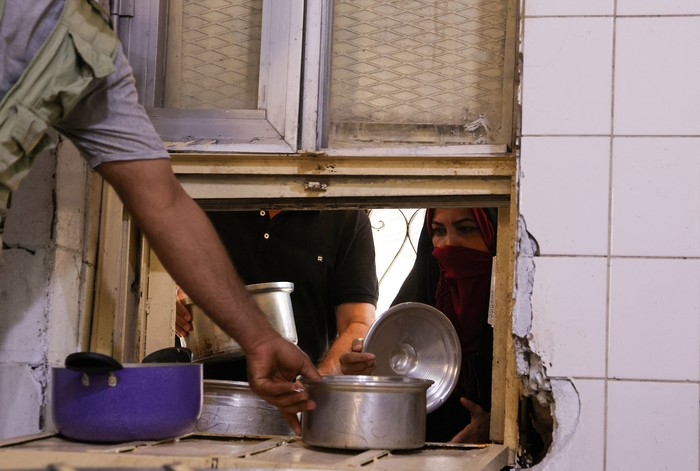 Dapur Umum Ramadan di Negeri 1001 Malam A man receives free food distributed to the needy during the fasting month of Ramadan at the Abdul-Qadir al-Gailani mosque in Baghdad, Iraq, April 17, 2022. REUTERS/Ahmed Saad