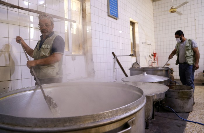 Dapur Umum Ramadan di Negeri 1001 Malam A man receives free food distributed to the needy during the fasting month of Ramadan at the Abdul-Qadir al-Gailani mosque in Baghdad, Iraq, April 17, 2022. REUTERS/Ahmed Saad