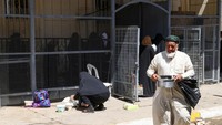 Warga meninggalkan kompleks masjid dengab membawa makanan buka puasa gratis di Masjid Abdul Qadir Al-Jailani, Baghdad, Irak, Minggu (17/4/2022).