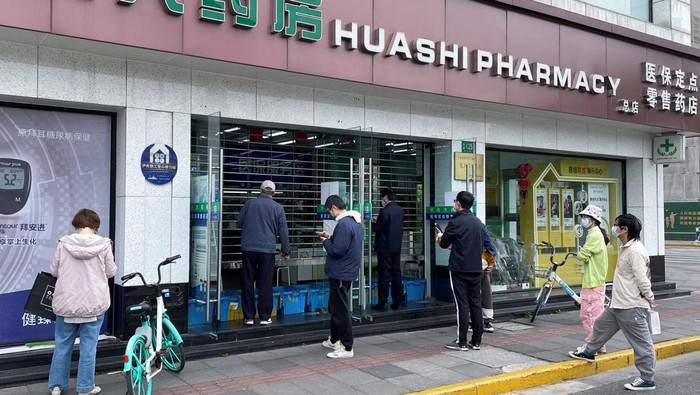 People wait outside a pharmacy to buy products, as the city eases the lockdown in some areas, amid the coronavirus disease (COVID-19) outbreak in Shanghai, China April 16, 2022. REUTERS/Brenda Goh