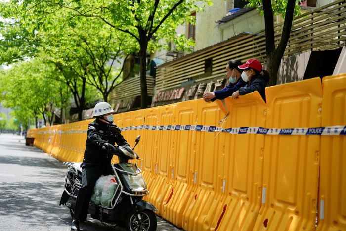 Residents stand on a street waiting for nucleic acid test during lockdown amid the coronavirus disease (COVID-19) pandemic, in Shanghai, China, April 17, 2022. REUTERS/Aly Song