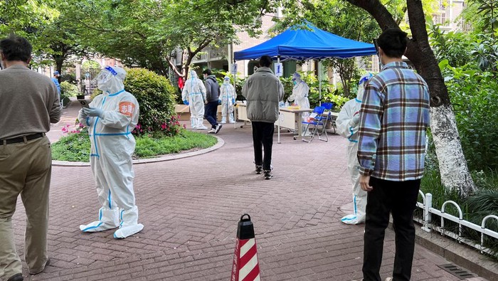 Residents get tested for the coronavirus disease (COVID-19) at a makeshift nucleic acid testing site inside a residential compound under lockdown, in Shanghai, China April 18, 2022. REUTERS/Xihao Jiang NO RESALES. NO ARCHIVES.
