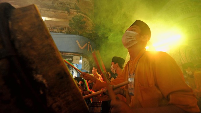 Peserta Festival Arakan Sahur Tahun 2022 memainkan alat musik tradisional di samping gerobak dorong dengan pernak-pernik bernuansa Islam di Kuala Tungkal, Tanjungjabung Barat, Jambi, Minggu (17/4/2022) dini hari. Festival budaya yang sempat terhenti selama 2 tahun terakhir akibat pandemi COVID-19 itu kembali digelar Pemerintah Kabupaten Tanjungjabung Barat. ANTARA FOTO/Wahdi Septiawan/foc.