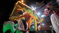 Peserta Festival Arakan Sahur Tahun 2022 memainkan alat musik tradisional di samping gerobak dorong dengan pernak-pernik bernuansa Islam di Kuala Tungkal, Tanjungjabung Barat, Jambi, Minggu (17/4/2022) dini hari.