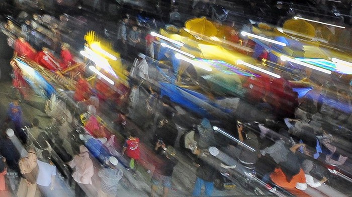 Peserta Festival Arakan Sahur Tahun 2022 memainkan alat musik tradisional di samping gerobak dorong dengan pernak-pernik bernuansa Islam di Kuala Tungkal, Tanjungjabung Barat, Jambi, Minggu (17/4/2022) dini hari. Festival budaya yang sempat terhenti selama 2 tahun terakhir akibat pandemi COVID-19 itu kembali digelar Pemerintah Kabupaten Tanjungjabung Barat. ANTARA FOTO/Wahdi Septiawan/foc.
