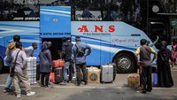Sejumlah calon penumpang bus memasukkan barang bawaannya ke dalam bagasi bus di Terminal Poris Plawad, Kota Tangerang, Banten.
