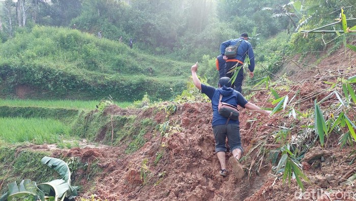 Warga Cilengkong Berusaha Melintasi Akses Utama yang Tertutup Longsor.