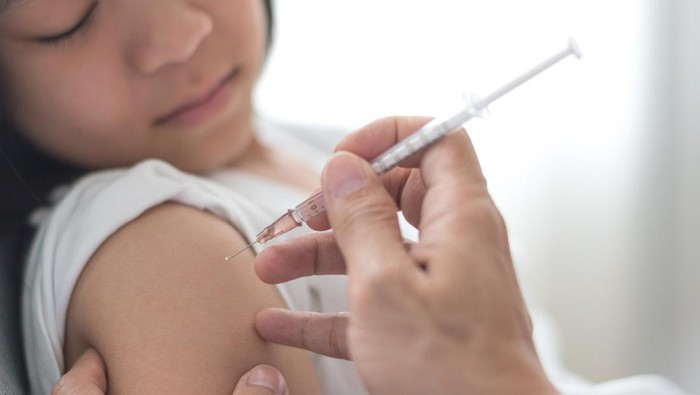 1316009633 Young doctor giving COVID 19 vaccine to young woman at home