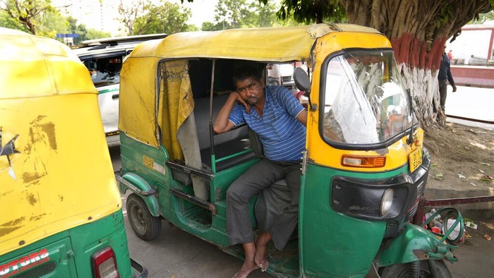 An auto-rickshaw driver sits in his vehicle during a strike called by private transport operators in New Delhi, Monday, April 18, 2022. Various auto-rickshaw and taxi unions in the national capital went on a day long strike Monday demanding subsidy for compressed natural gas and a fare revision in the wake of rising fuel prices. (AP Photo/Manish Swarup)