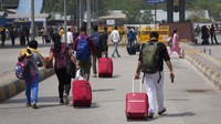 Penumpang berjalan dengan barang bawaannya mencari moda transportasi lain saat mogok kerja yang diserukan oleh operator transportasi swasta di New Delhi.