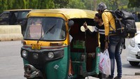 Penumpang bernegosiasi dengan pengemudi bajaj di luar stasiun kereta api selama aksi mogok.
