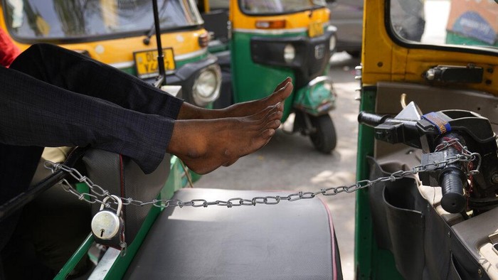 Aksi Mogok Sopir Bajaj dan Taksi di India, Penumpang Terlantar An auto-rickshaw driver sits in his vehicle during a strike called by private transport operators in New Delhi, Monday, April 18, 2022. Various auto-rickshaw and taxi unions in the national capital went on a day long strike Monday demanding subsidy for compressed natural gas and a fare revision in the wake of rising fuel prices. (AP Photo/Manish Swarup)