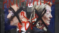 Para demonstran mencoret-coret poster 2 kandidat Capres Prancis, Emmanuel Macron dan Marine Le Pen dalam aksi di Porte de Saint Denis, Paris, Prancis, Senin, (18/4/2022).