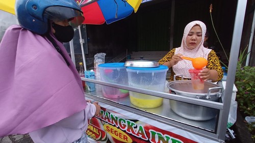 Umi Kulsum (kanan) saat menyajikan Es Semangka India kepada pembeli.