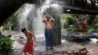 Sejumlah warga Kolkata, India, terlihat berkumpul di lokasi pipa air yang bocor, Selasa (19/4/2022) untuk mendinginkan badan selama terjangan cuaca panas.