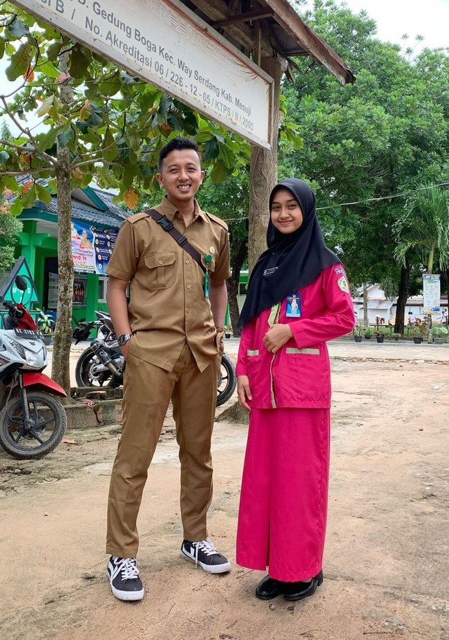 Kisah kepala sekolah yang menikahi muridnya viral setelah diunggah akun TikTok @fajrulfaj. Dalam video yang berdurasi 20 detik itu terlihat perjalanan cinta sang kepala sekolah dan muridnya mulai dari awal kenal, dekat, lamaran hingga ingin berlanjut ke jenjang pernikahan. Akun TikTok @fajrulfaj tak menduga cerita cintanya seperti kisah yang ada di Wattpad. Foto: Dok. pribadi Fajrul.