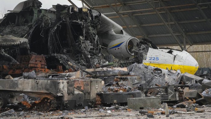 Mengais Sisa-sisa Ranjau Aktif di Bangkai Pesawat Antonov A Ukrainian sapper searches for unexploded explosives as he passes by an Antonov An-225, world's biggest cargo aircraft destroyed during recent fighting between Russian and Ukrainian forces, at the Antonov airport in Hostomel, on the outskirts of Kyiv, Ukraine, Monday, April 18, 2022. (AP Photo/Efrem Lukatsky)