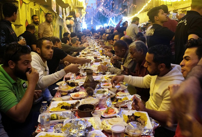 Residents of Ezbet Hamada gather to eat during Iftar gathering, a meal to end their fast at sunset, during the holy fasting month of Ramadan in Mataria, Cairo, Egypt, April 16, 2022. Picture taken April 16, 2022. REUTERS/ Fatma Fahmy NO RESALES. NO ARCHIVES