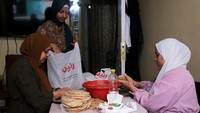 Perempuan muslim menyiapkan makanan berbuka untuk kaum pria dari dapur apartemen.