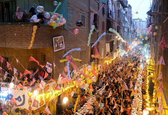 RELIGION-RAMADAN/EGYPT-BANQUETS Residents of Ezbet Hamada gather to eat during Iftar gathering, a meal to end their fast at sunset, during the holy fasting month of Ramadan in Mataria, Cairo, Egypt, April 16, 2022. Picture taken April 16, 2022. REUTERS/ Fatma Fahmy NO RESALES. NO ARCHIVES