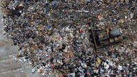 Foto udara TPA West New Territories selama pandemi penyakit coronavirus (COVID-19), di Hong Kong. Sebuah alat berat merapikan gunungan sampah.