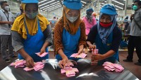 Buruh menghitung uang THR yang disalurkan secara tunai.