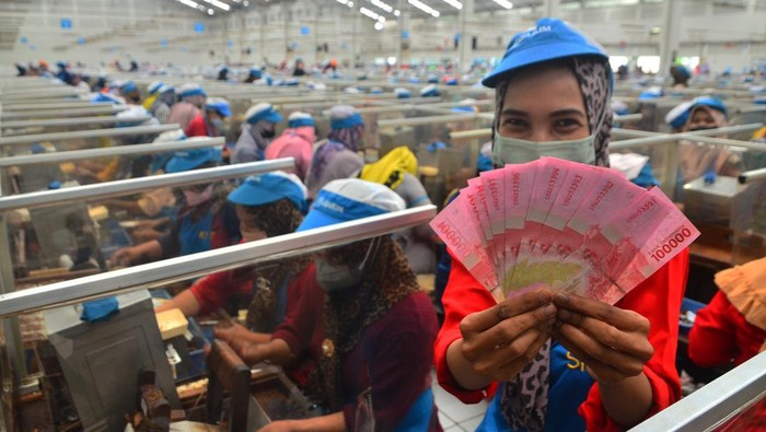 Pekerja menghitung uang Tunjangan Hari Raya (THR) yang diterimanya di pabrik rokok PT Djarum, Kudus, Jawa Tengah, Selasa (19/4/2022). Sebanyak 52.025 pekerja harian dan borongan yang tersebar di tujuh kota di perusahaan itu telah menerima uang THR guna membantu mereka dalam memenuhi kebutuhan keluarga selama bulan Ramadhan dan Idul Fitri. ANTARA FOTO/Yusuf Nugroho/wsj.