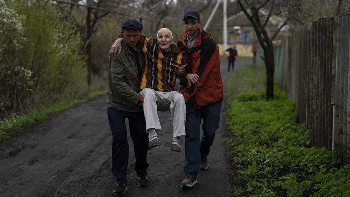 Elderly people are evacuated from a hospice in Chasiv Yar city, Donetsk district, Ukraine, Monday, April 18, 2022. At least 35 men and women, some in wheelchairs and most of them with difficulties to walk, were helped by volunteers to flee from the region that has been under attack in the last weeks. They are going to Khmelnytskyi, western Ukraine. (AP Photo/Petros Giannakouris)