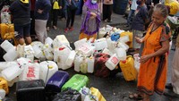 Warga mengantre dengan membawa jeriken yang diletakkan berderet di halaman distributor minyak goreng curah di Makassar.