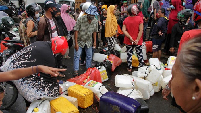 Warga Makassar Rela Antre Panjang Demi Migor Curah Warga menderetkan jerigen saat mengantre untuk membeli minyak goreng curah di salah satu distributor di Makassar, Sulawesi Selatan, Selasa (19/4/2022). Warga setempat lebih memilih membeli minyak goreng curah seharga Rp15.500 per kilogram meskipun harus mengantre serta menunjukkan Kartu Tanda Penduduk (KTP) daripada membeli minyak goreng kemasan yang harganya mahal. ANTARA FOTO/Arnas Padda/nym.