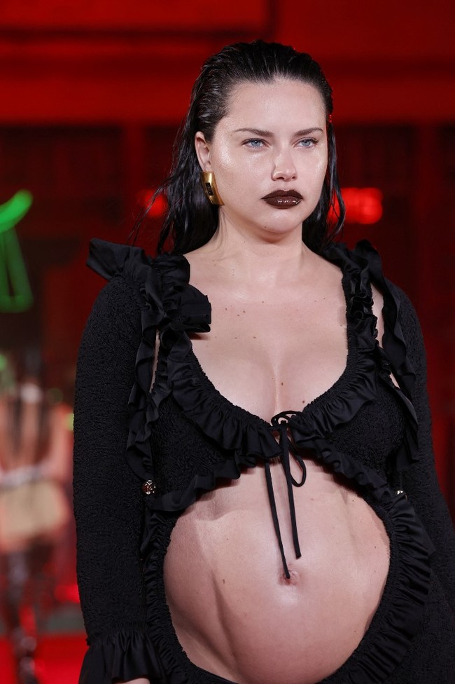 Terlihat perut model 40 tahun itu seperti berotot dengan pahatan yang tegas. Gayanya yang edgy ini juga kian maksimal dengan lipstick berwarna gelap dan rambut wet-look. (Foto: Getty Images via AFP/FRAZER HARRISON)