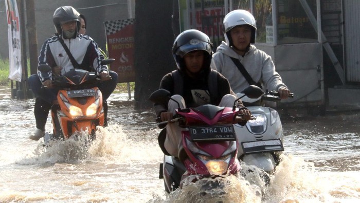 Banjir merendam kawasan Cikancung, Kabupaten Bandung. Tak sedikit pengendara yang nekat menerobos banjir demi beraktivitas meski ada yang berakhir mogok.