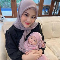Sambil dipangku Aurel Hermansyah, baby Ameena yang mengenakan setelan hijab berwarna ungu itu tampil menggemaskan. Penampilan baby Ameena saat mengenakan hijab pun diunggah ke Instagram dan berhasil bikin netizen heboh karena ikut merasa gemas. Foto: Instagram