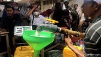 Beberapa petugas sibuk melakukan pendataan hingga pengisian minyak goreng curah ke dalam jerigen.