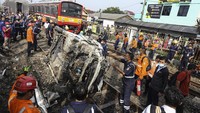 Sejumlah petugas melakukan evakuasi mobil yang tertabrak KRL di kawasan Rawageni, Cipayung, Depok, Jawa Barat, Rabu (20/4/2022).