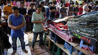 Salat 5 waktu menjadi wajib bagi setiap muslim. Sementara salat Jumat wajib bagi laki-laki muslim sehinga tetap melaksanakan meski di antara kesibukan perdagangan pasar. (AP Photo/Achmad Ibrahim)
