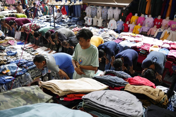 People perform Friday prayer at Tanah Abang market during Ramadan in Jakarta, Indonesia, Friday, April 15, 2022. Muslims across the world are observing the holy fasting month of Ramadan, where they refrain from eating, drinking and smoking from dawn to dusk. (AP Photo/Achmad Ibrahim)