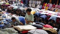 Para pedagang salat Jumat di sela-sela lapaknya di Pasar Tanah Abang, Jakarta, Jumat (15/4/2022). (AP Photo/Achmad Ibrahim)