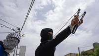 Pemuda Palestina melakukan perlawanan kepada pendudukan Israel di desa Burqa, Tepi Barat. Mereka menggunakan katapel saat berhadapan dengan polisi Israel yang dipersenjatai dengan gas air mata.