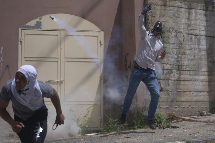 Israel Palestinians Israeli border police use teargas to disperse Palestinian protesters during clashes in the West Bank village of Burqa, north of Nablus, Tuesday, April 19, 2022. Palestinians protesting against a settlers march toward Homesh, a settlement that was officially dismantled by Israel in 2005, clashed with Israeli border police that closed the main entrance of the village to secure the event. (AP Photo/Nasser Nasser)